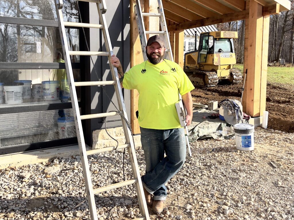 Sam the Painter stands by a ladder