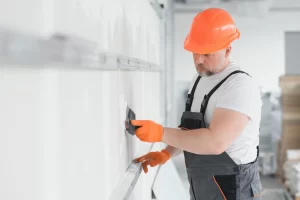 Professional drywall repair contractor finishing a drywall seam